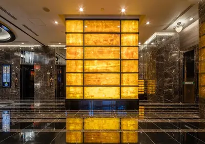 a lobby with a large yellow wall in a building at APA Hotel Asakusa Tawaramachi Ekimae in Tokyo