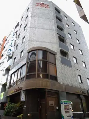 a tall building with a sign on the side of it at Nishishinjuku Green Hotel in Tokyo