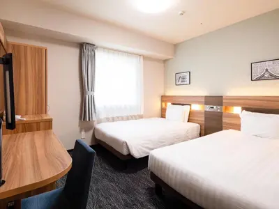 a hotel room with two beds and a desk at Comfort Hotel ERA Tokyo Higashi Kanda in Tokyo