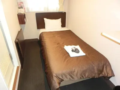 a small room with a bed in a room at Hotel Suntargas Otsuka in Tokyo