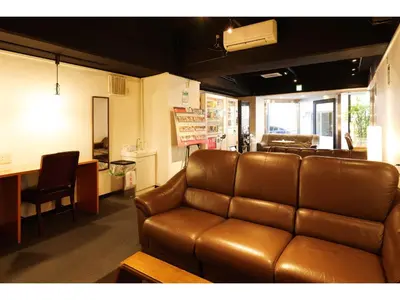 a living room with a leather couch and a table at Hotel Suntargas Otsuka in Tokyo