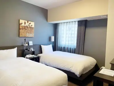 a hotel room with two beds and a window at Hotel Route-Inn Tokyo Kamata -Ayamebashi- in Tokyo