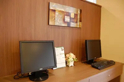 a desk with two computer monitors and a keyboard at Hotel Route-Inn Tokyo Kamata -Ayamebashi- in Tokyo