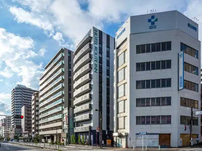 a tall white building on a city street at Hotel Route-Inn Tokyo Kamata -Ayamebashi- in Tokyo