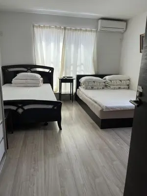 two beds in a room with a wooden floor at Tokyo Ikebukuro Takahashi Minsyuku in Tokyo