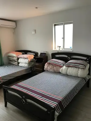 a room with two beds and a window at Tokyo Ikebukuro Takahashi Minsyuku in Tokyo