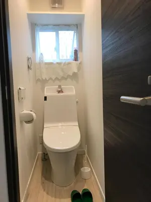 a bathroom with a white toilet and a window at Tokyo Ikebukuro Takahashi Minsyuku in Tokyo