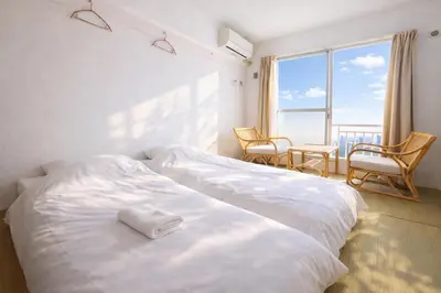 a hotel room with two beds and a window at Sakura Hotel Nippori in Tokyo