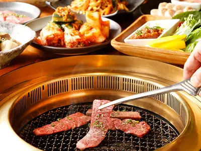 a grill with meat on it with plates of food at Centurion Hotel&Spa Ueno Station in Tokyo
