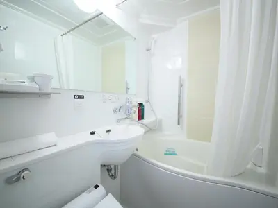 a white bathroom with a sink and a bath tub at APA Hotel Akihabaraeki-Denkigaiguchi in Tokyo