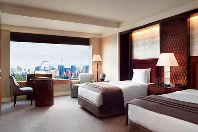 a hotel room with two beds and a large window at The Ritz-Carlton, Tokyo in Tokyo