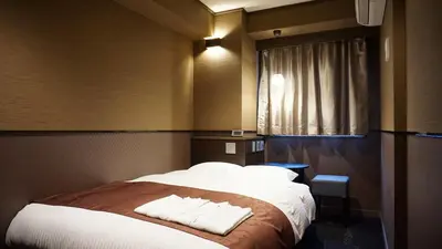 a bedroom with a bed with two towels on it at Hotel SUI Ginza Kyobashi by ABEST in Tokyo