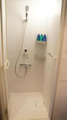a bathroom with a shower with a hose at Hotel SUI Ginza Kyobashi by ABEST in Tokyo