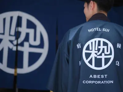 a man wearing a shirt with the h toll sun logo at Hotel SUI Ginza Kyobashi by ABEST in Tokyo