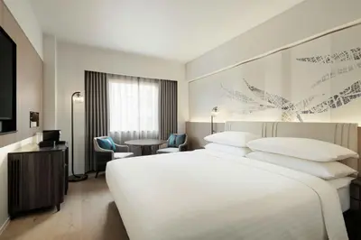 a hotel room with a white bed and a table and chairs at Courtyard by Marriott Tokyo Ginza Hotel in Tokyo