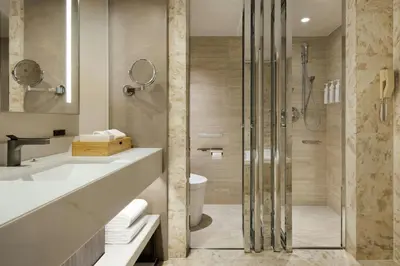 a bathroom with a shower and a sink and a toilet at Courtyard by Marriott Tokyo Ginza Hotel in Tokyo