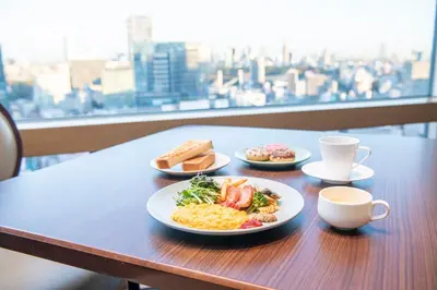 a table with plates of food and a cup of coffee at Shibuya Excel Hotel Tokyu in Tokyo