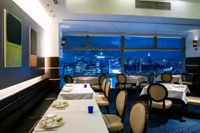 a restaurant with tables and chairs and a view of a city at Shibuya Excel Hotel Tokyu in Tokyo