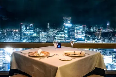 a table with two glasses and a view of a city at Shibuya Excel Hotel Tokyu in Tokyo