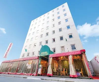 a tall white building with tables in front of it at Sakura Hotel Ikebukuro in Tokyo
