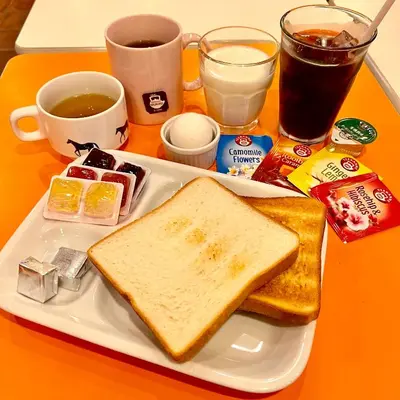 a white plate with toast and jelly and other breakfast foods at Sakura Hotel Ikebukuro in Tokyo
