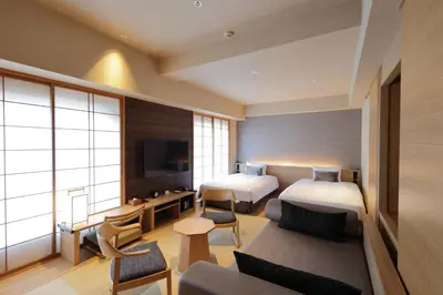 a hotel room with two beds and a couch at Hotel Niwa Tokyo in Tokyo