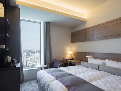 a hotel room with a bed and a large window at Nihon Seinenkan Hotel in Tokyo