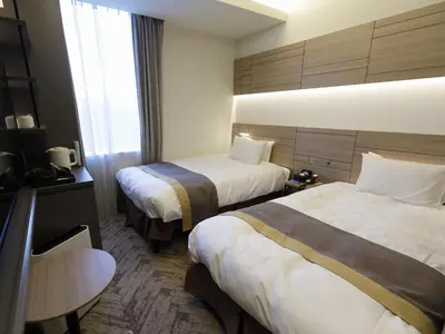 a hotel room with two beds and a table at Nihon Seinenkan Hotel in Tokyo