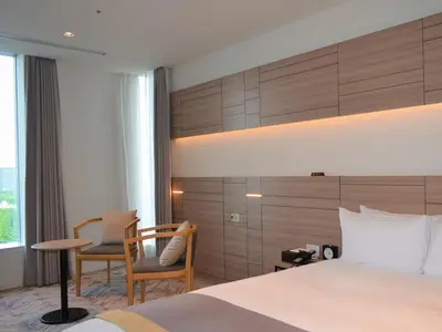 a hotel room with a bed and a desk and chairs at Nihon Seinenkan Hotel in Tokyo