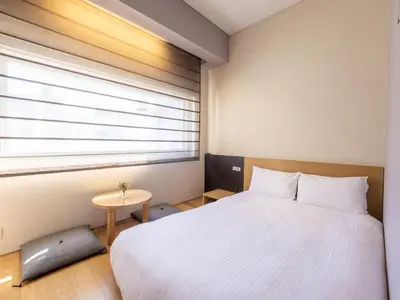 a bedroom with a white bed and a window at Hotel Gracery Ginza in Tokyo