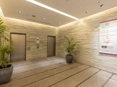 a lobby with two potted plants in a building at Hotel Gracery Ginza in Tokyo