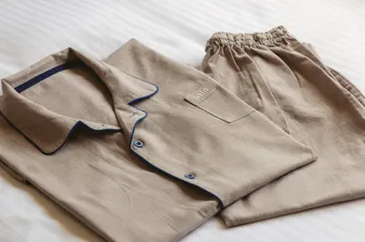 a brown shirt and pants laying on a bed at Hotel Gracery Tokyo Tamachi in Tokyo