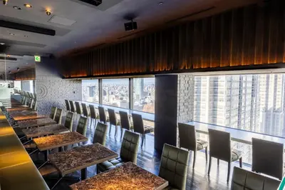 a restaurant with tables and chairs and a large window at Shinjuku Washington Hotel in Tokyo
