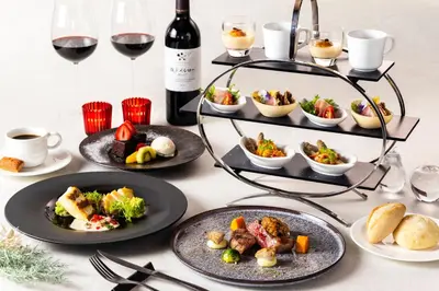 a table with plates of food and glasses of wine at Shinjuku Washington Hotel in Tokyo