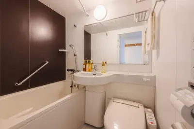 a bathroom with a toilet and a sink and a bath tub at Shinjuku Washington Hotel in Tokyo