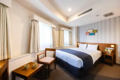 a hotel room with a bed and a chair at Shinjuku Washington Hotel in Tokyo