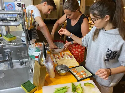 a group of people preparing food in a kitchen at Sakura Hostel Asakusa in Tokyo