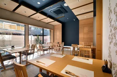 a dining room with wooden tables and chairs at Hotel Rose Garden Shinjuku in Tokyo