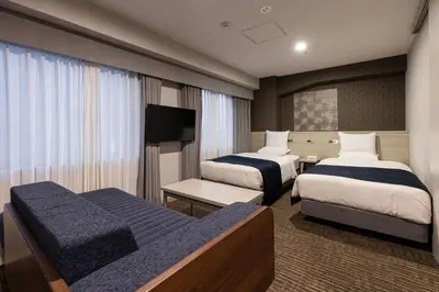 a hotel room with two beds and a flat screen tv at Hotel Rose Garden Shinjuku in Tokyo