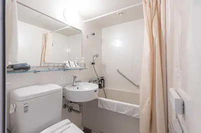 a white bathroom with a sink and a toilet at Hotel Rose Garden Shinjuku in Tokyo