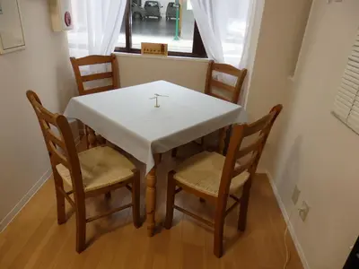 a table and chairs with a white table and a window at Backpacker's Mini House in Tokyo