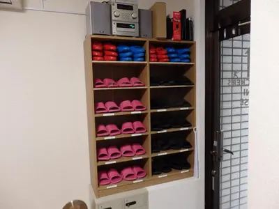 a closet with a bunch of shoes on shelves at Backpacker's Mini House in Tokyo