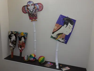 a shelf with two kites and some toys on it at Backpacker's Mini House in Tokyo