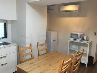 a kitchen with a table and chairs and a microwave at TIMES INN 2F in Tokyo