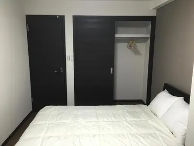 a bedroom with a white bed and two black doors at TIMES INN 2F in Tokyo