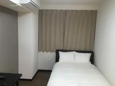 a bedroom with a bed with white sheets and a window at TIMES INN 2F in Tokyo