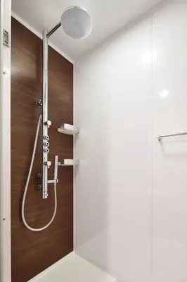 a shower in a bathroom with a wooden wall at the b shimbashi in Tokyo