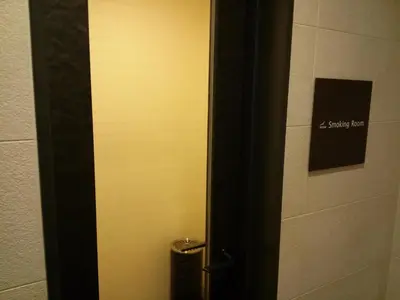 a bathroom door with a trash can next to a wall at the b shimbashi in Tokyo
