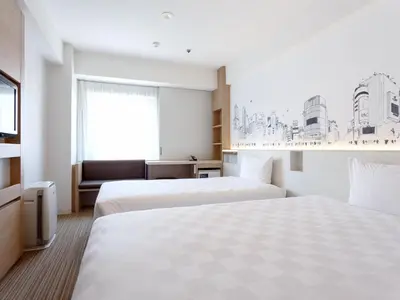 a hotel room with two beds and a tv at Shibuya Tokyu REI Hotel in Tokyo