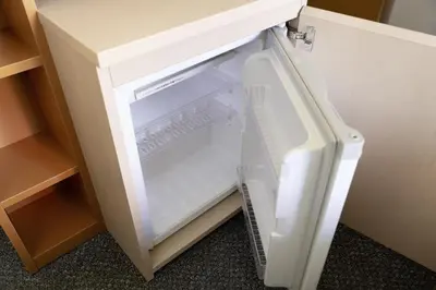 an empty refrigerator with its door open in a cabinet at Shibuya Tokyu REI Hotel in Tokyo